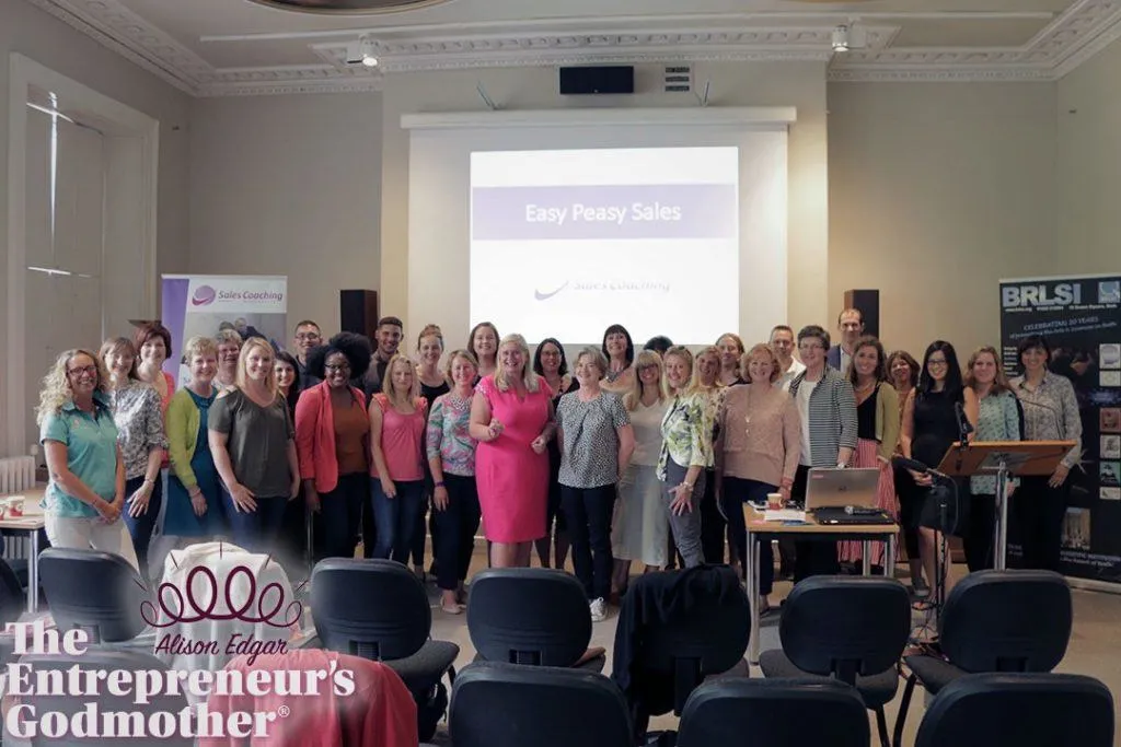 Alison, centre in pink, with the room at one of her Easy Peasy Sales coaching workshops, badged “The Entrepreneur’s Godmother”.