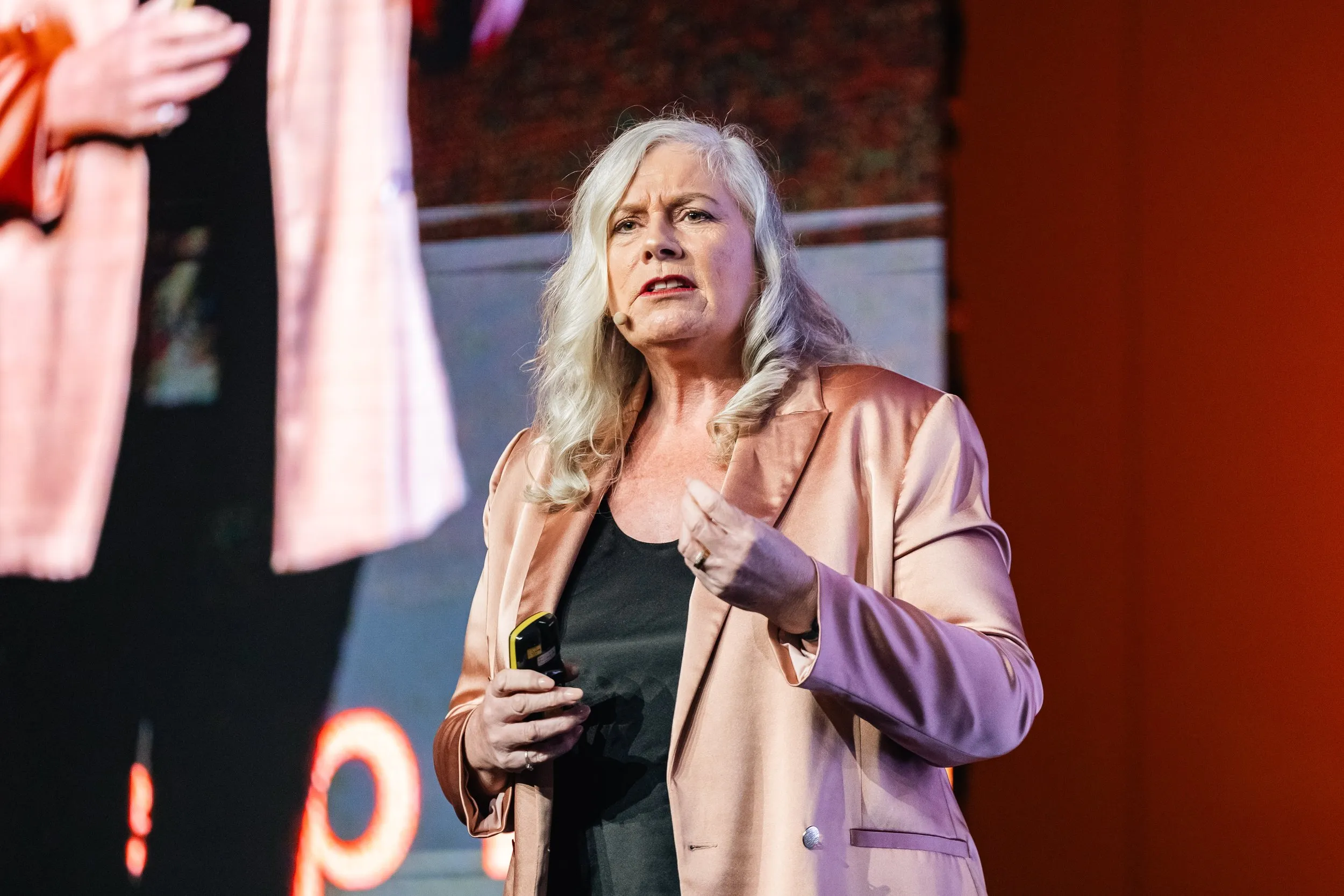 Dr Alison Edgar MBE delivering a keynote on stage.